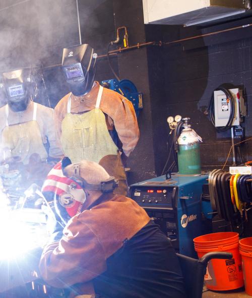 students and instructor in a welding lab
