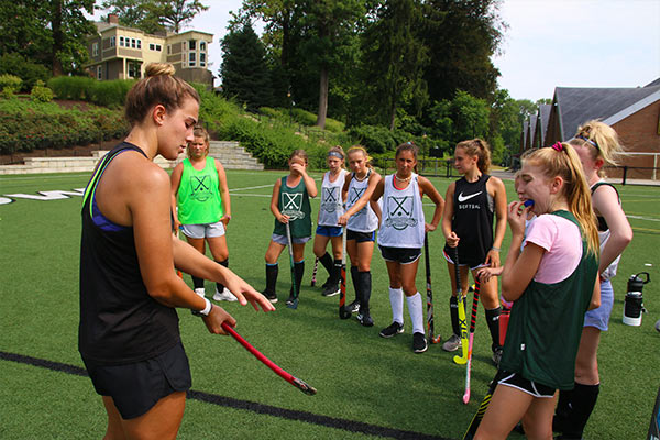 children being instructed on field hocky