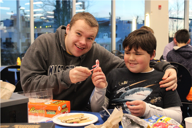 a cadet and a kid holding up candy canes