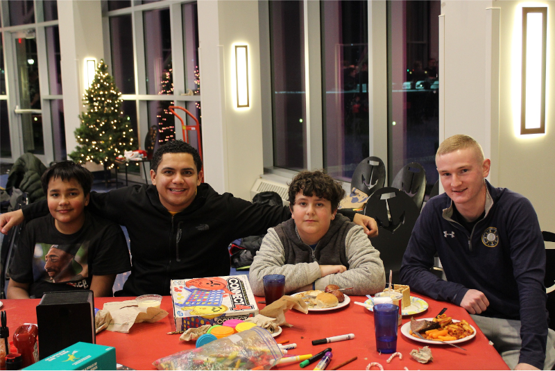 Group of children sitting at table with games and a cadet