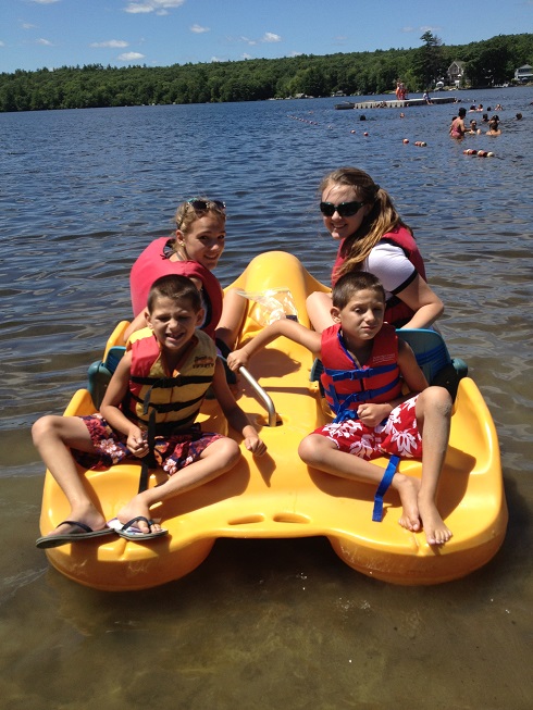 Brett and 3 other children on a boat in a lake