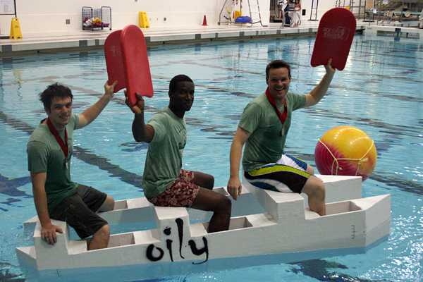 college students paddling cardboard boats