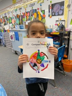 preschool child holding colored compass rose