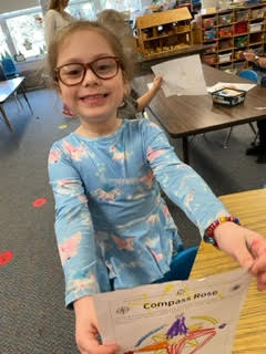 preschool child holding colored compass rose