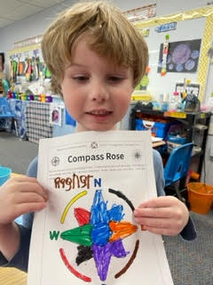 preschool child holding colored compass rose