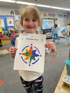 preschool child holding colored compass rose