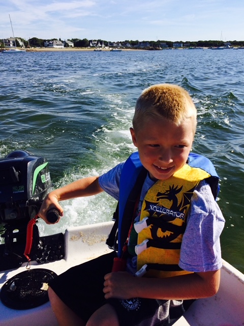 Dean as a child driving a boat.