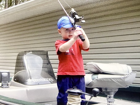 young Hunter fishing from a boat in the yard