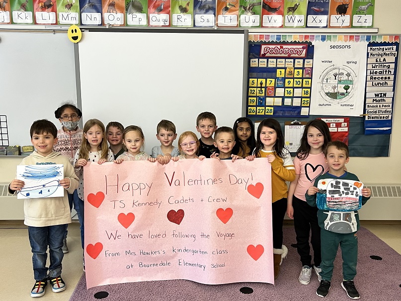 kindergarteners hold valentine's day banner