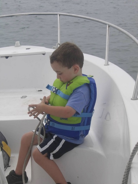 young joe on the deck of a motorboat