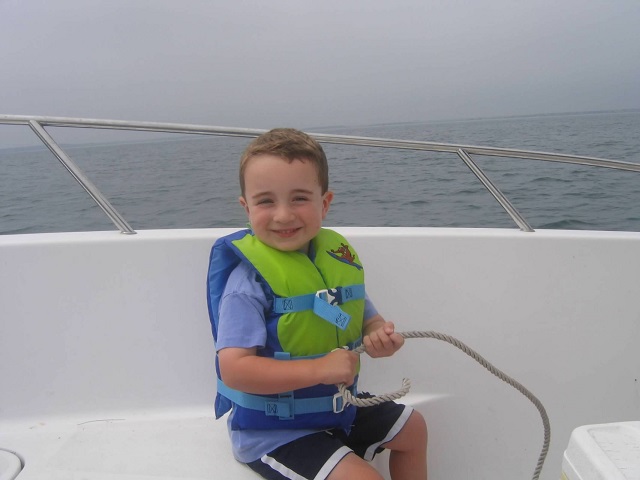 toddler joe holding a line on a boat