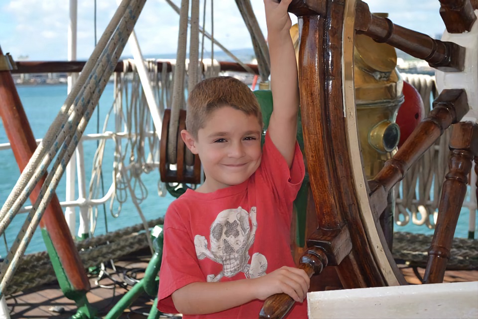 Kaleb at a ship's wheel