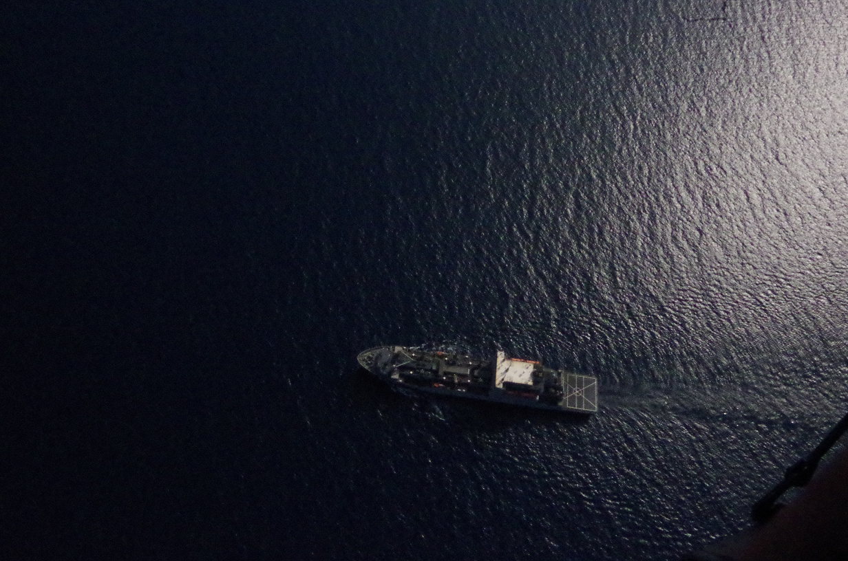 drone shot of ship in black ocean