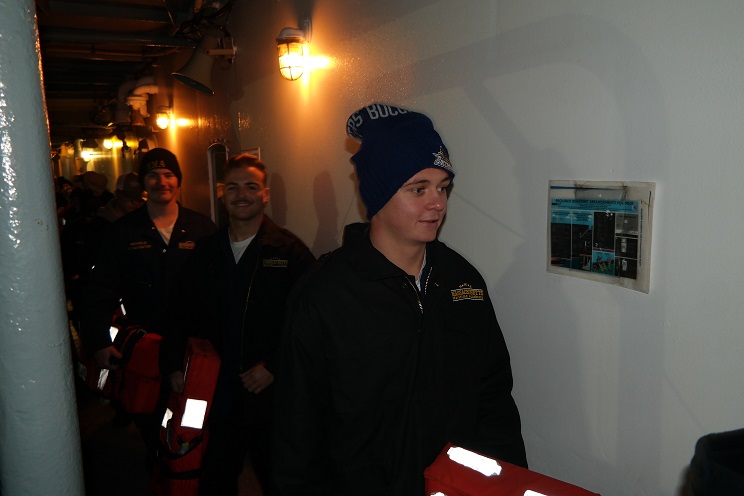 cadets carrying lifejackets on deck