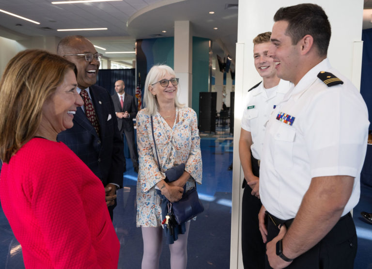 Two Cadets and Three administrators standing in the mess deck smiling