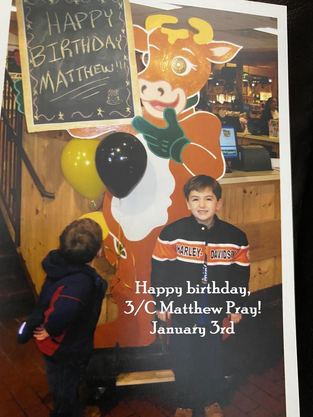 young boy in front of a happy birthday sign