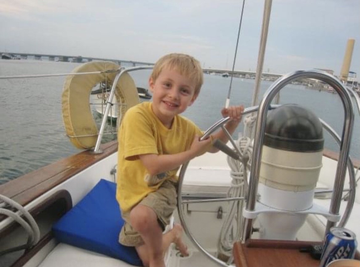 Nate holding a ship's wheel