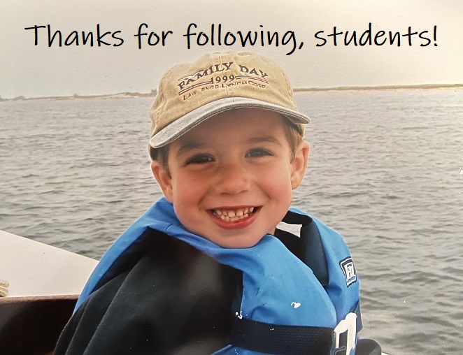 Nick is on a boat wearing a baseball hat.