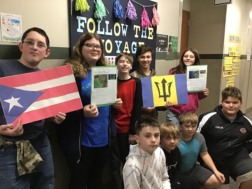 middle school students holding port flags and reports