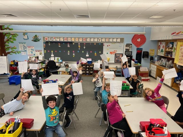 students holding up papers