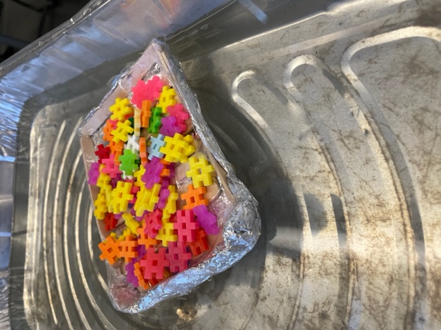 student made lifeboat in small basin of water