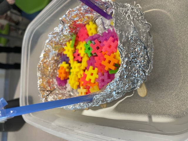 student made lifeboat in small basin of water