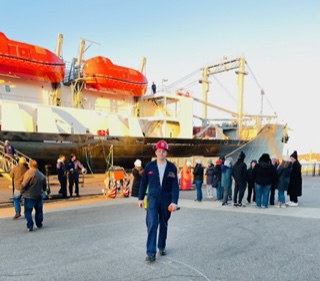 cadet in front of ship