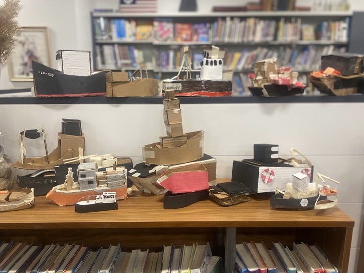 students carboard boats on shelves