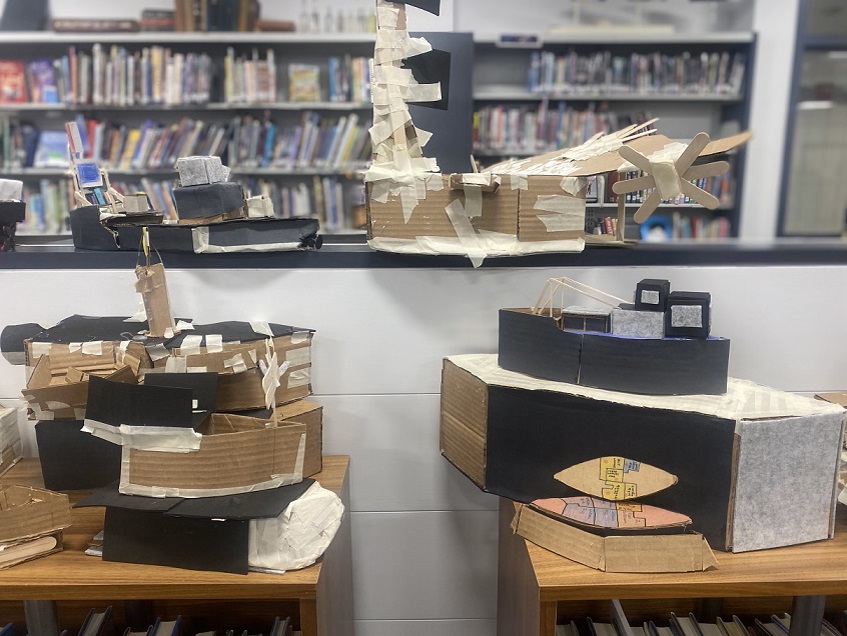 students carboard boats on shelves