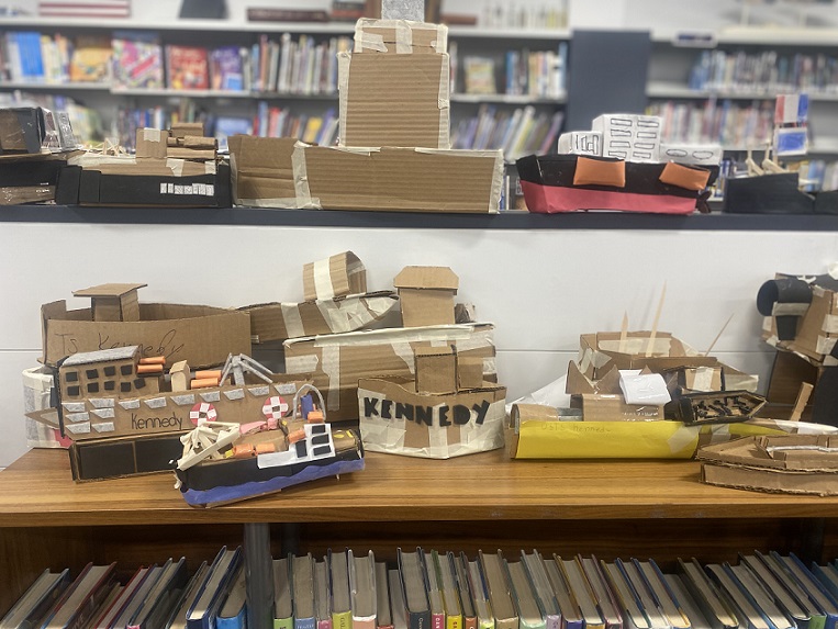 students carboard boats on shelves