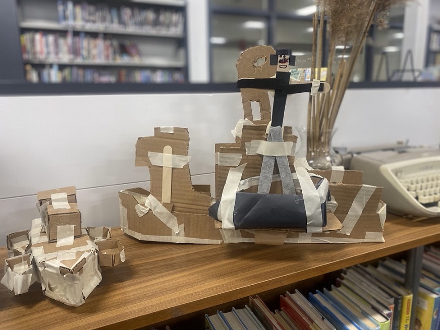 students carboard boats on shelves