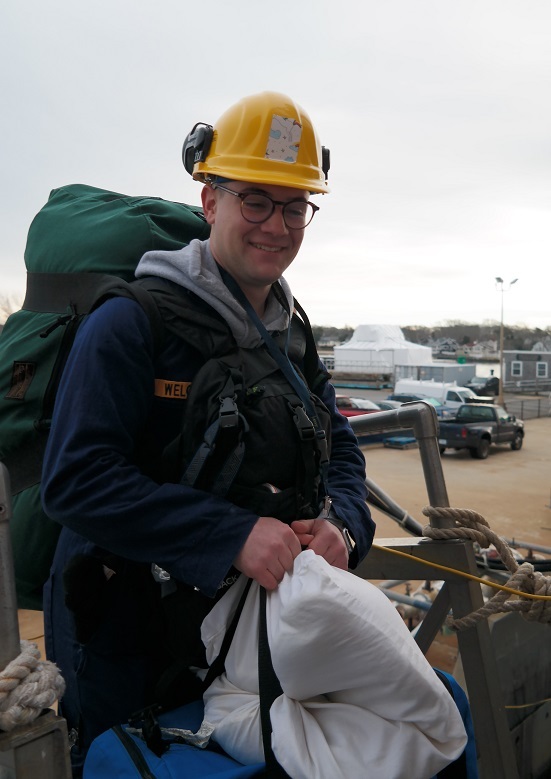 cadets carry sea bags onto ship