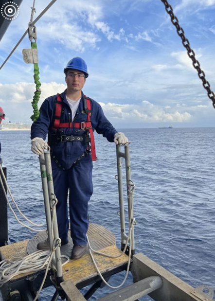 cadet stands on gangway over ocean