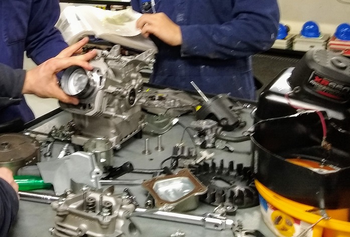 students taking apart lawnmower engine