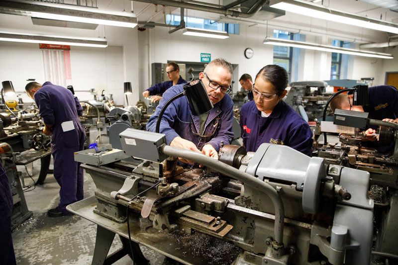 a cadet with an instructor in the machine tool lab