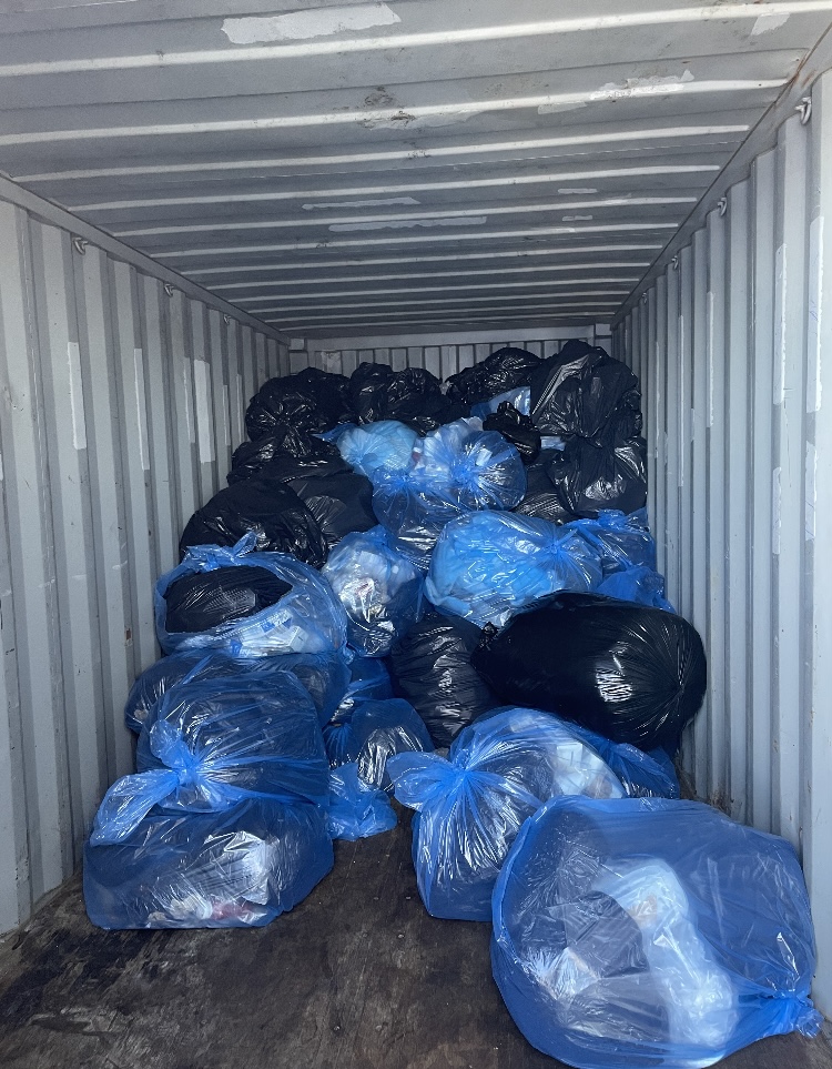 blue bags of trash in container
