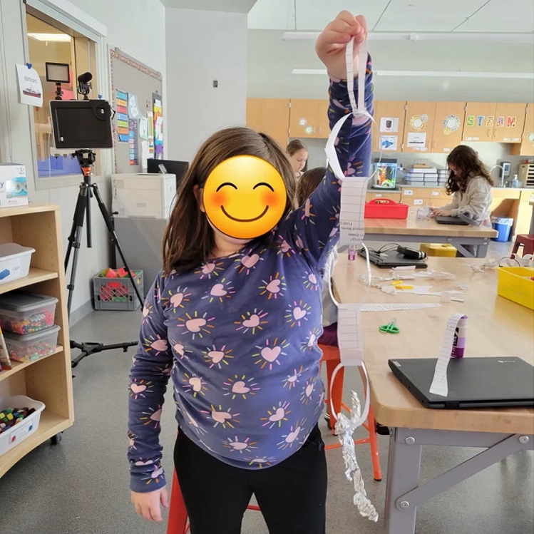 student holding paper anchor and chain