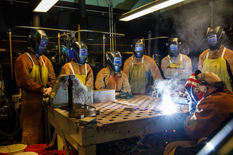 cadets in the welding lab with an instructor welding