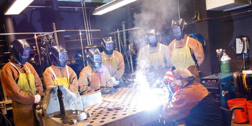 students and instructor in a welding lab